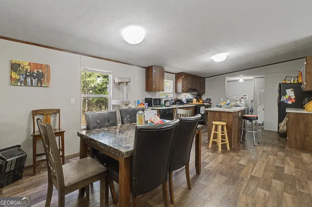 a view of a dining room with furniture and a kitchen