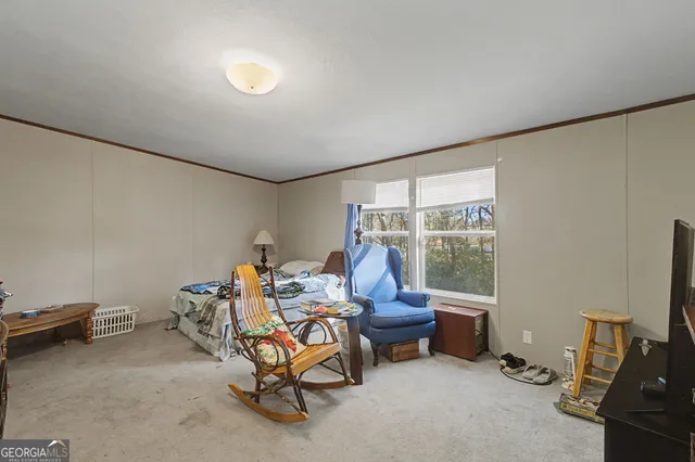 a living room with furniture a flat screen tv and a window
