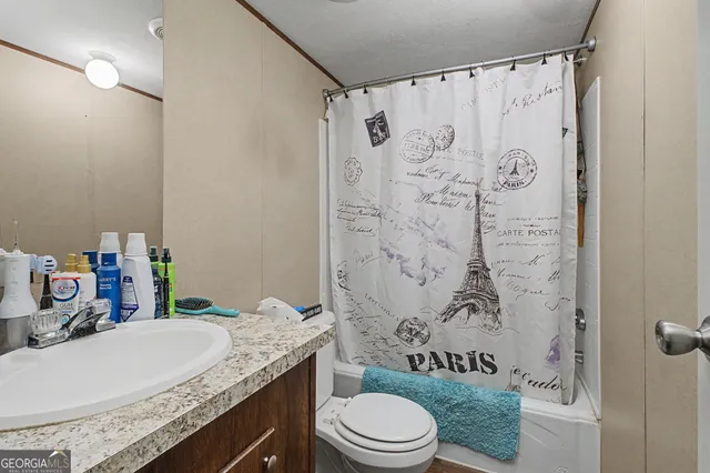 a bathroom with a granite countertop toilet sink and shower