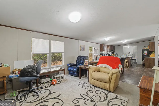 a living room with furniture a large window and gym equipment
