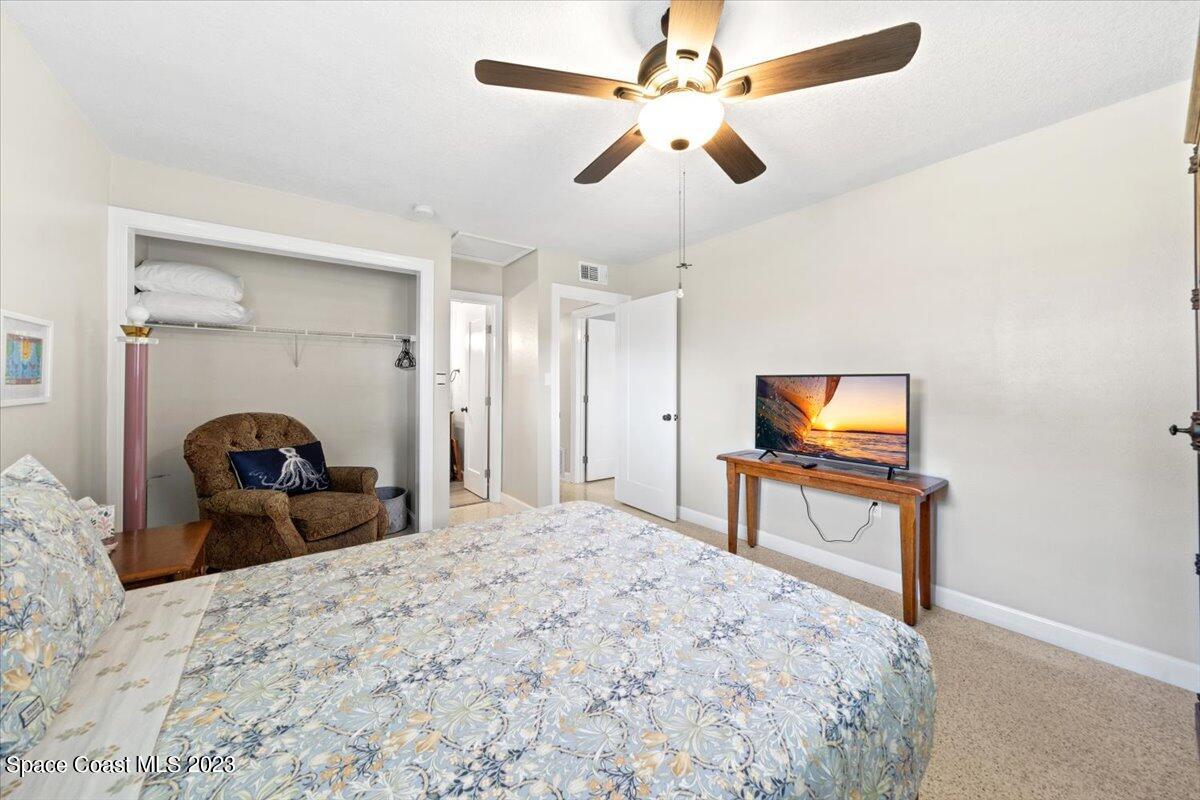 550 Capri Road Cocoa Beach, FL 32931 - Photo 17 of 36 a bedroom with a bed and a flat screen tv