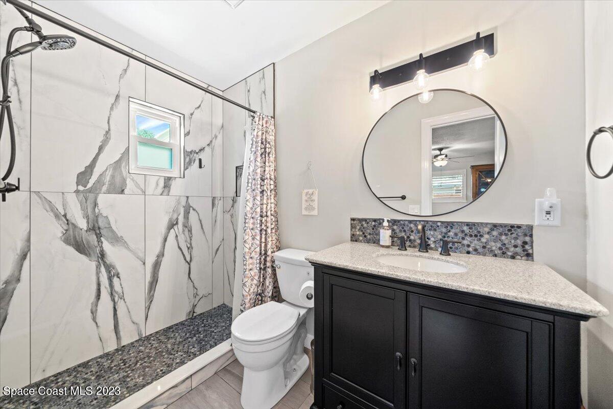 550 Capri Road Cocoa Beach, FL 32931 - Photo 18 of 36 a bathroom with a sink vanity mirror and toilet