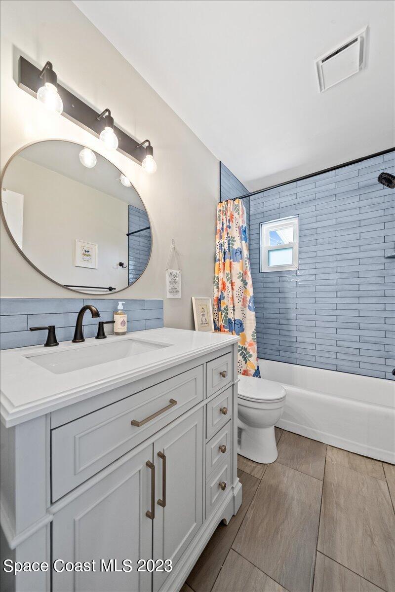 550 Capri Road Cocoa Beach, FL 32931 - Photo 20 of 36 a bathroom with a double vanity sink toilet and shower
