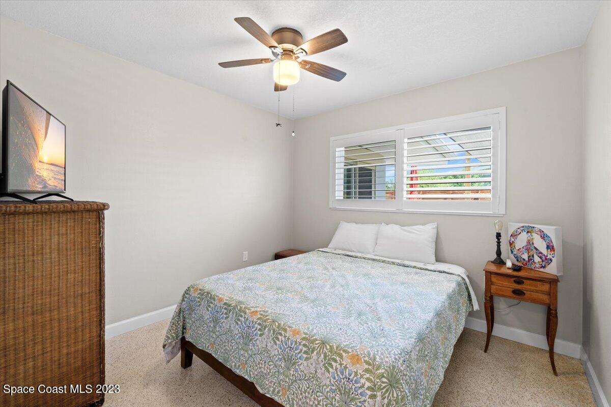 550 Capri Road Cocoa Beach, FL 32931 - Photo 21 of 36 a bedroom with a bed and a chandelier