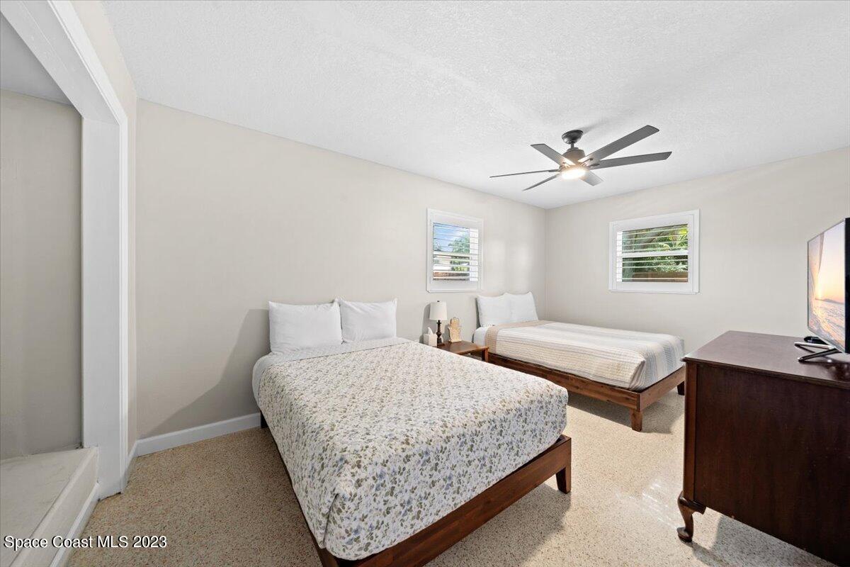 550 Capri Road Cocoa Beach, FL 32931 - Photo 22 of 36 a bedroom with a bed and a chandelier