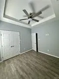 an empty room with a ceiling fan and window