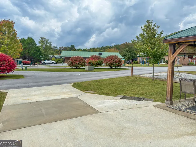 a view of a house with a big yard and a large trees