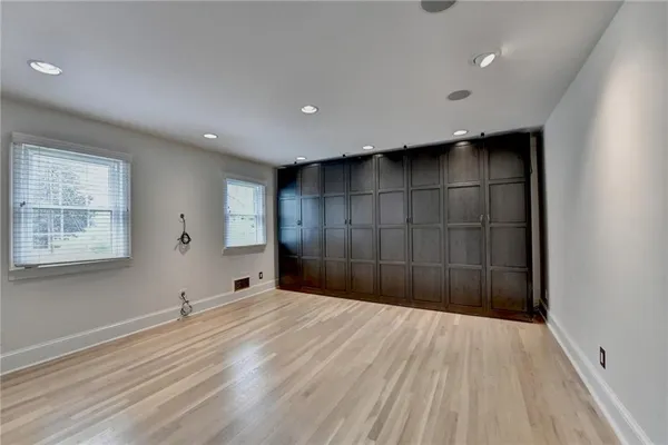 an empty room with a window and a ceiling fan