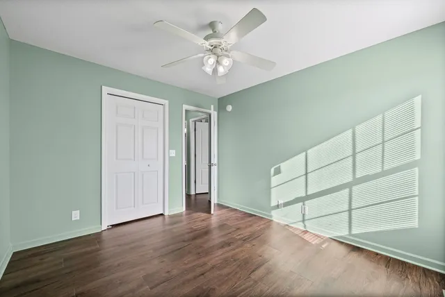 a view of an empty room with cabinet and a ceiling fan