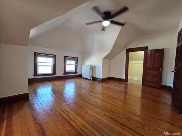 a view of empty room with wooden floor