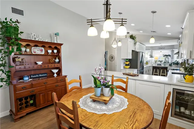 a kitchen with stainless steel appliances granite countertop a stove a kitchen island a dining table and chairs with wooden floor