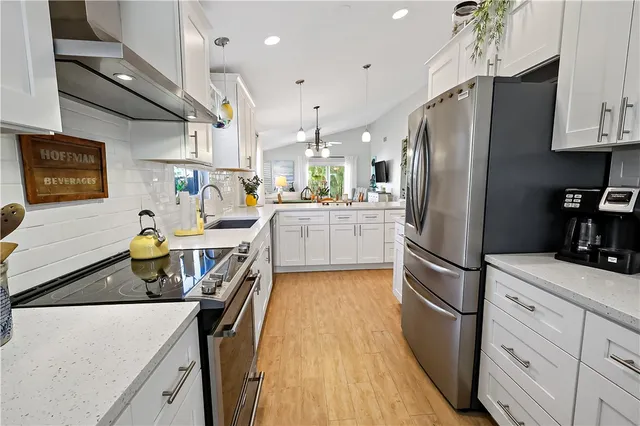 a kitchen with stainless steel appliances a refrigerator sink and wooden cabinets