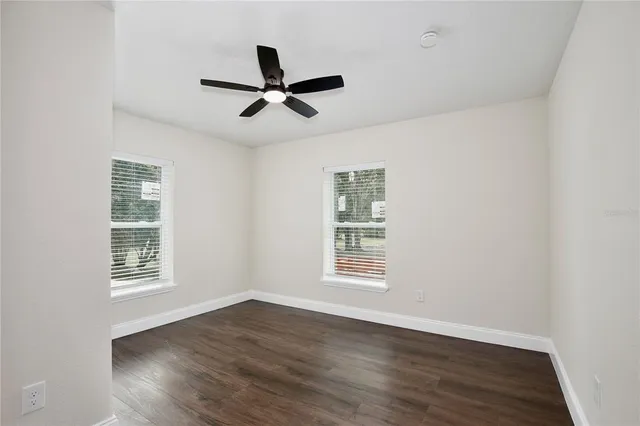 a view of a big room with wooden floor and windows