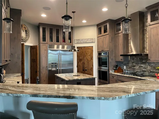 a kitchen with stainless steel appliances granite countertop a stove a sink and a refrigerator