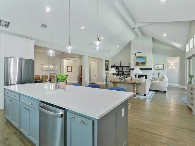 a large white kitchen with lots of counter space and refrigerator