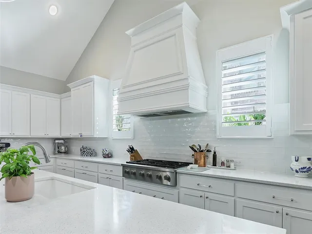 a kitchen with stainless steel appliances white cabinets and a window