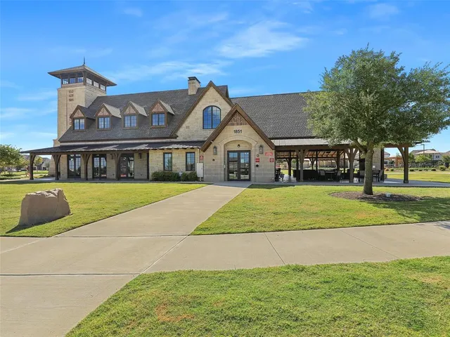 a view of house with a yard and potted plants