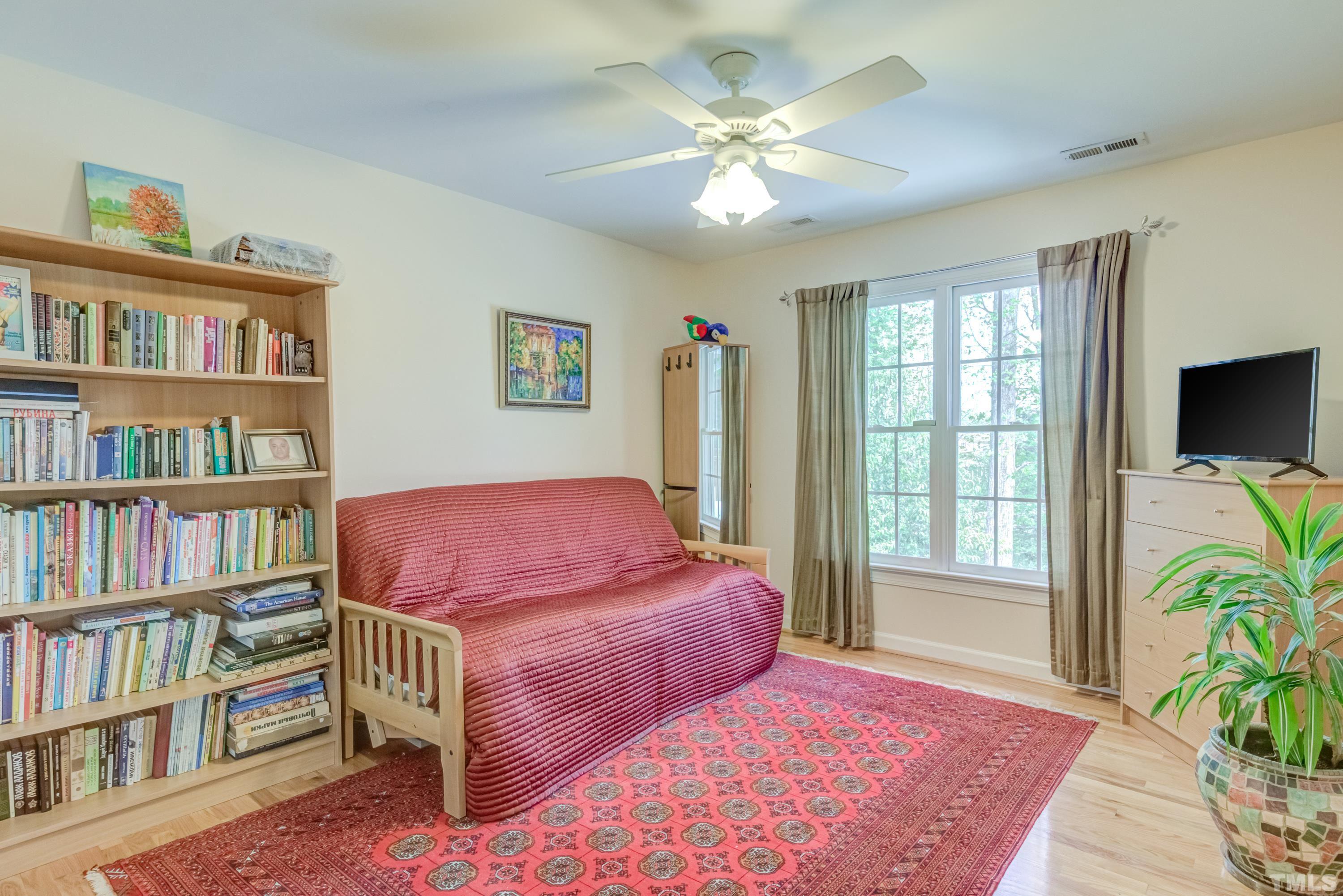 303 Evans Estates Drive Cary, NC 27513 - Photo 33 of 61 a bedroom with a bed book shelf and a window