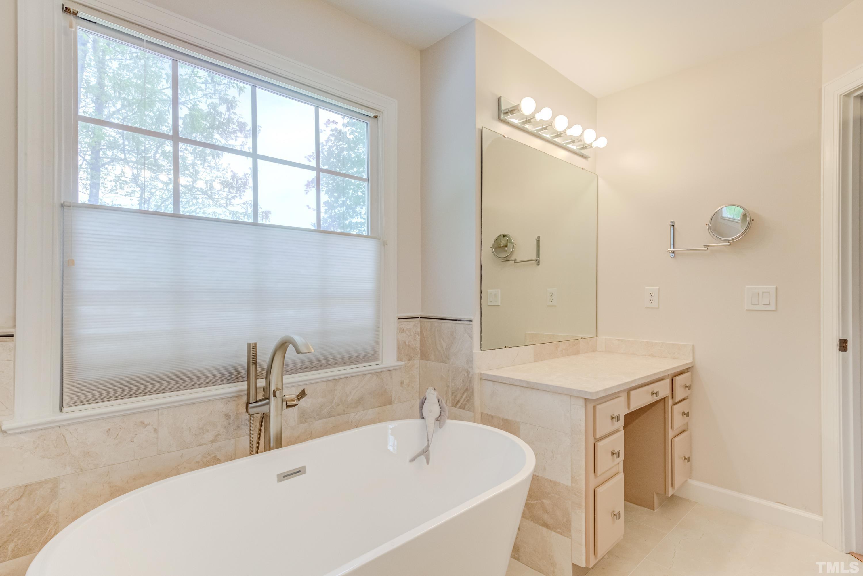 303 Evans Estates Drive Cary, NC 27513 - Photo 37 of 61 a bathroom with a tub a sink and a large mirror