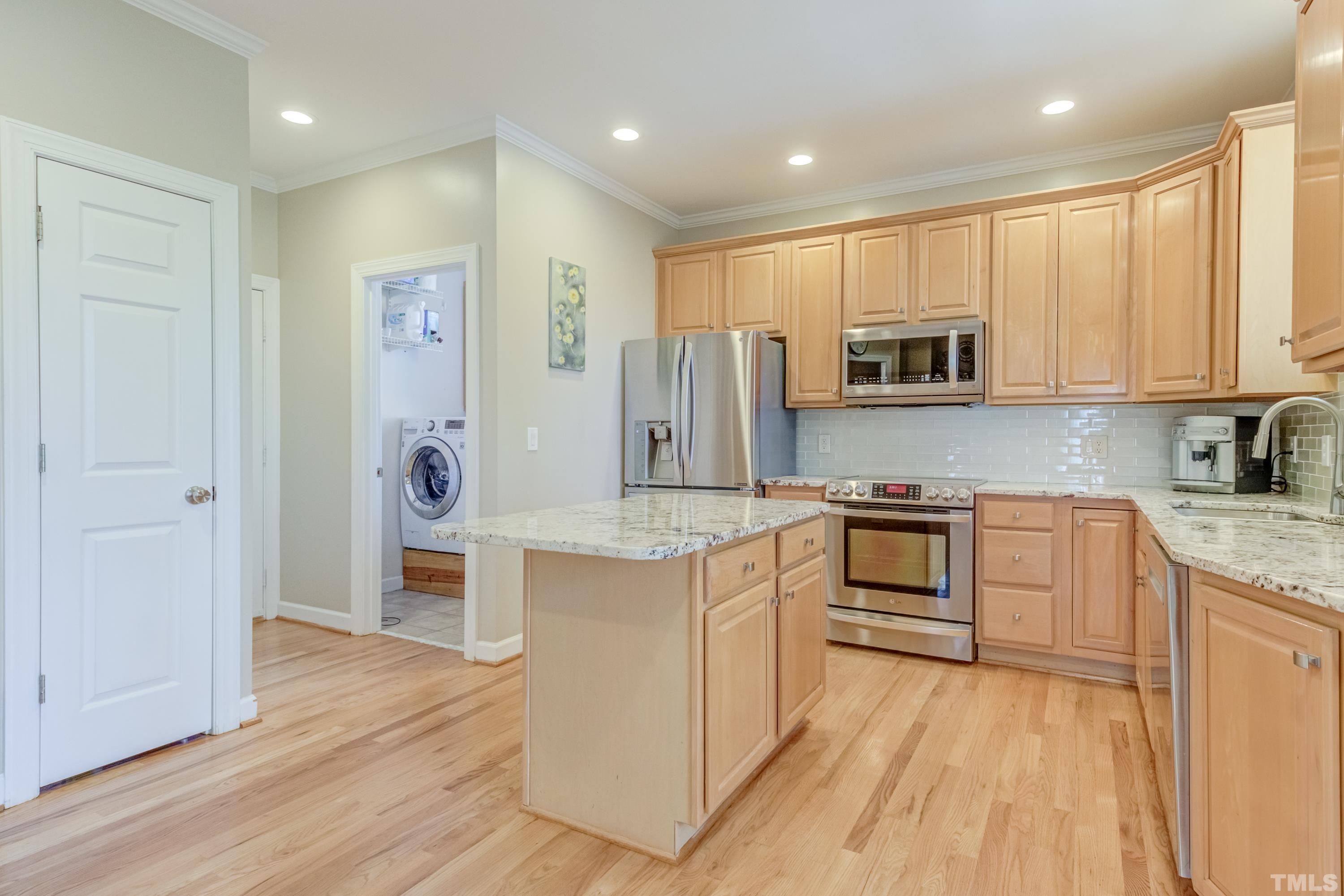 303 Evans Estates Drive Cary, NC 27513 - Photo 54 of 61 a kitchen with stainless steel appliances granite countertop a refrigerator a stove top oven a sink and dishwasher with wooden floor
