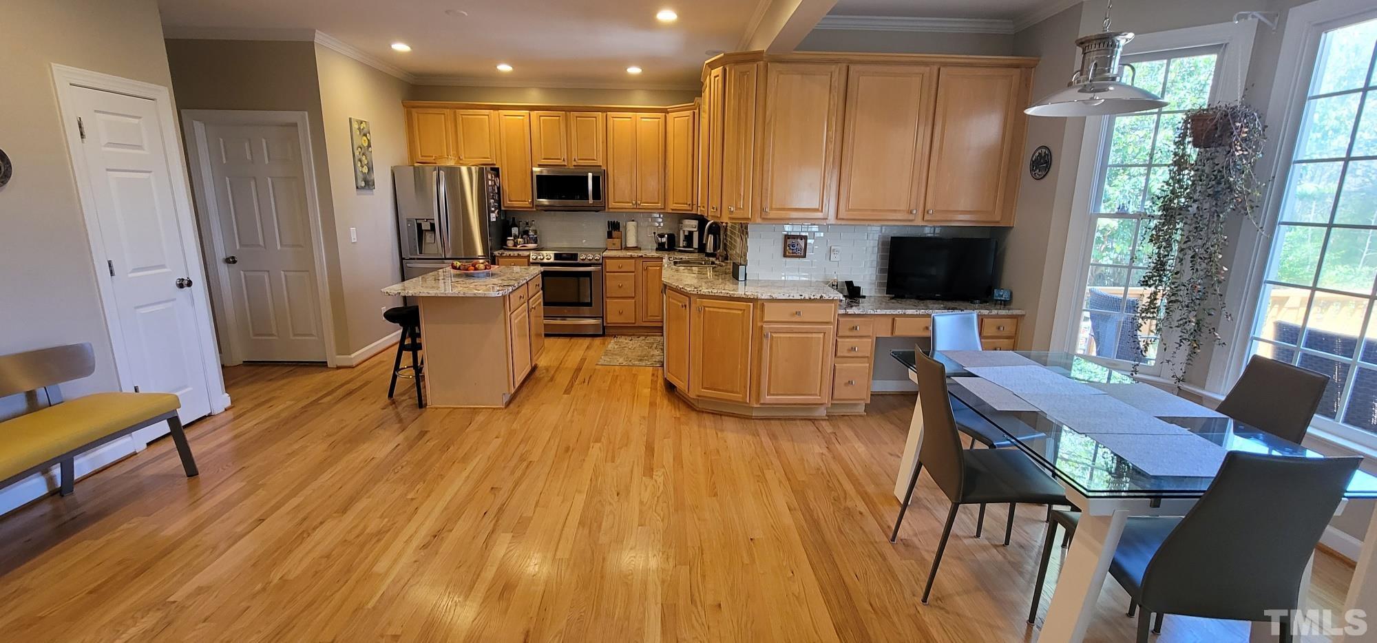 303 Evans Estates Drive Cary, NC 27513 - Photo 6 of 61 a living room with stainless steel appliances a dining table wooden floor and a window