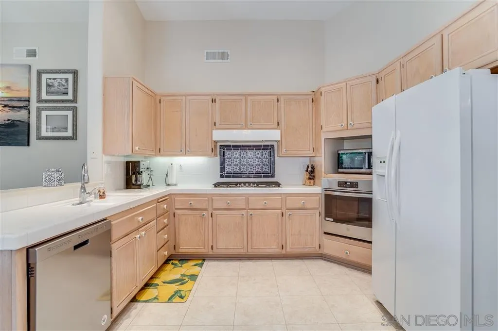 7570 Windy Ridge Road San Diego, CA 92126 - Photo 12 of 25 a kitchen with white cabinets and white appliances