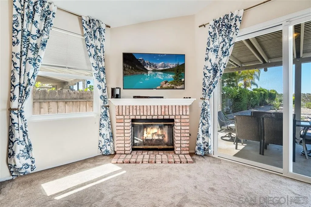 7570 Windy Ridge Road San Diego, CA 92126 - Photo 16 of 25 a living room with a fireplace and a flat screen tv
