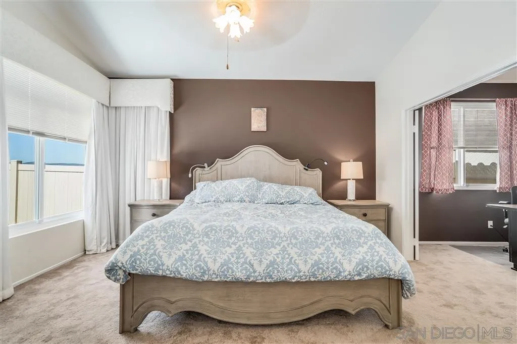 7570 Windy Ridge Road San Diego, CA 92126 - Photo 19 of 25 a bedroom with a bed and a chandelier