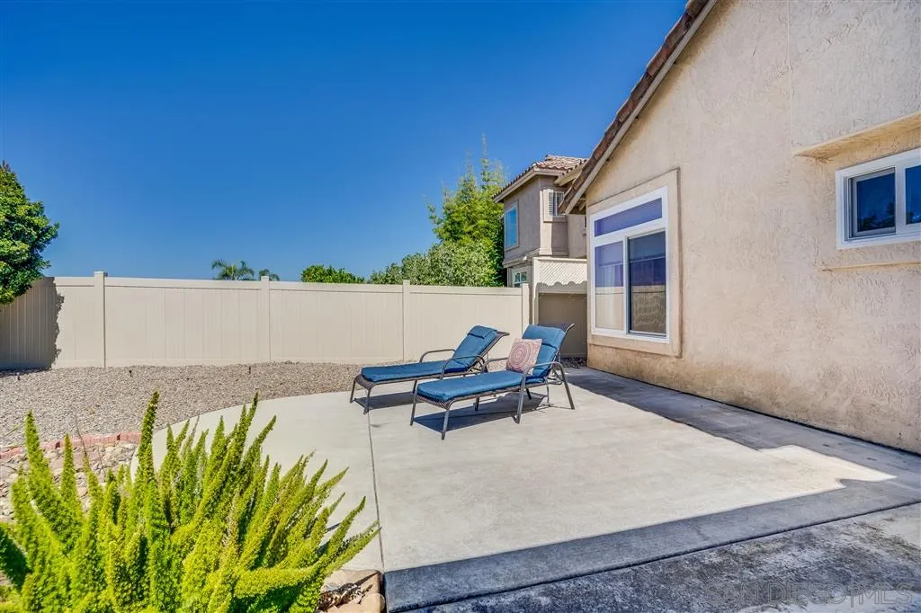 7570 Windy Ridge Road San Diego, CA 92126 - Photo 25 of 25 a roof deck with table and chairs under an umbrella with potted plants