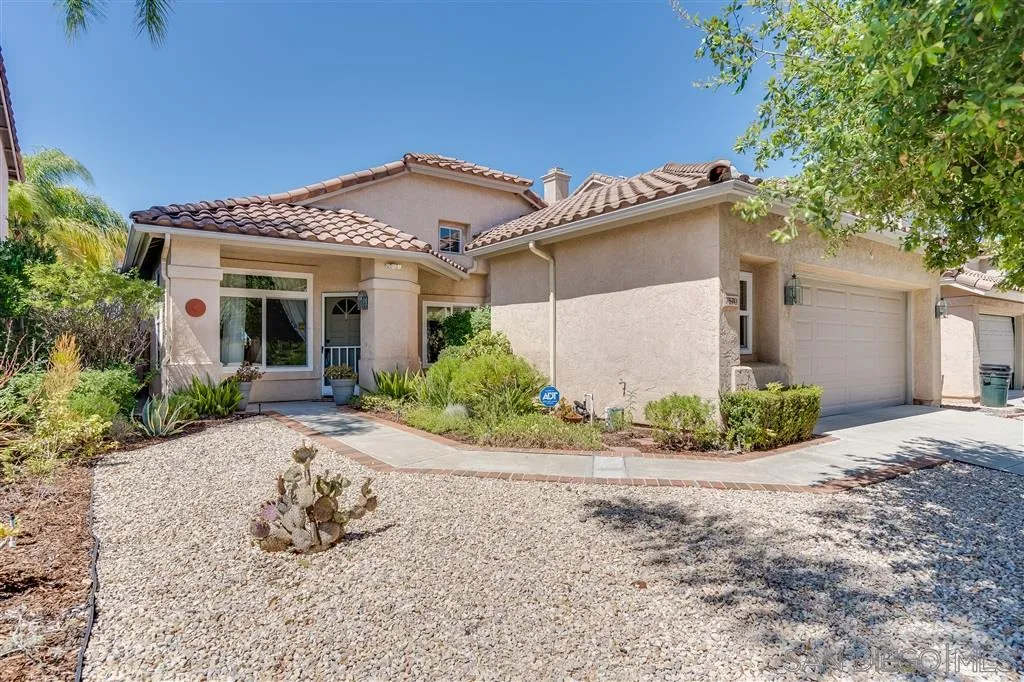 7570 Windy Ridge Road San Diego, CA 92126 - Photo 3 of 25 front view of a house with a bench