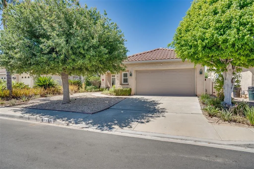 7570 Windy Ridge Road San Diego, CA 92126 - Photo 4 of 25 a front view of a house with a yard and garage