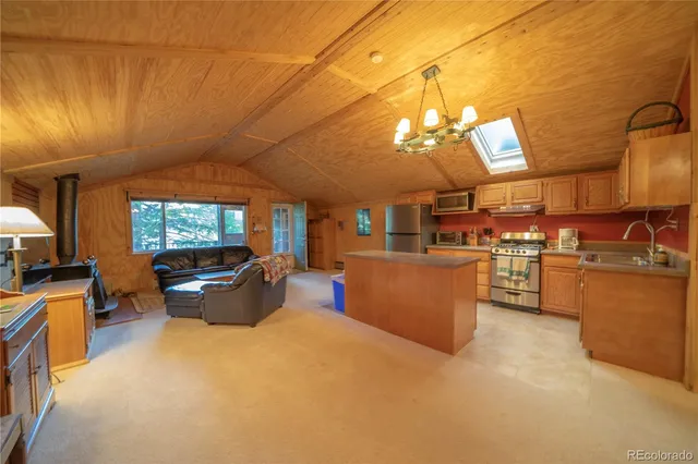 a living room with couches a flat screen tv and kitchen view