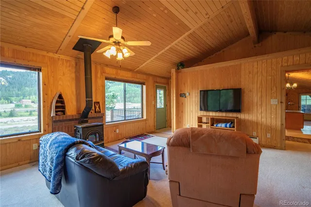 a living room with furniture a large window and flat screen tv