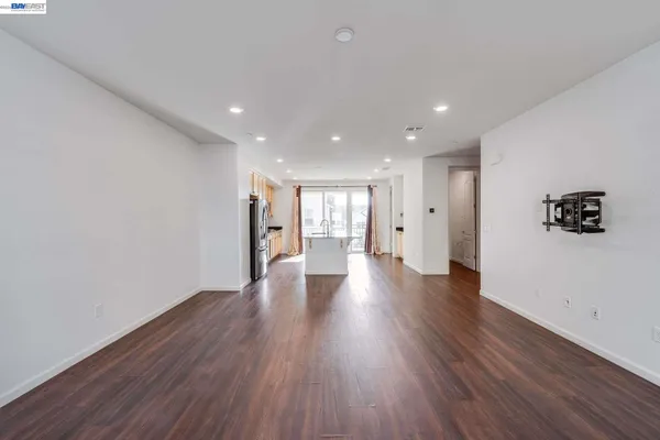 a view of a big room with wooden floor and windows