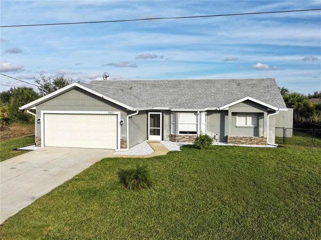 a front view of house with yard and garage