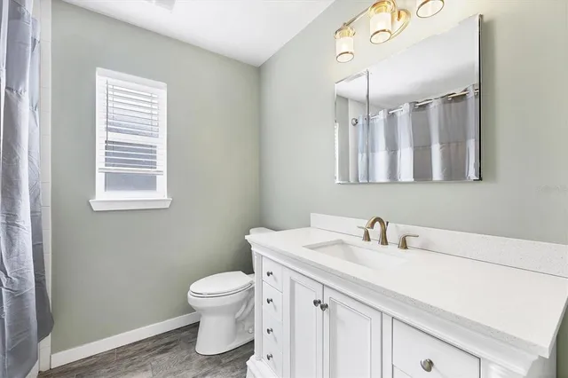 a bed sitting in a spacious bedroom next to a window