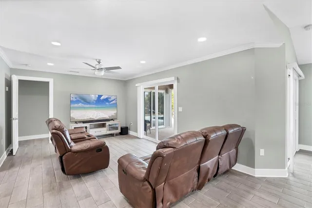 a living room with furniture a flat screen tv and a window