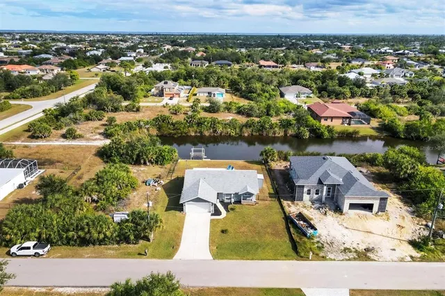 a view of a lake with a yard and large trees