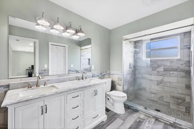 a bathroom with a double vanity sink mirror and toilet