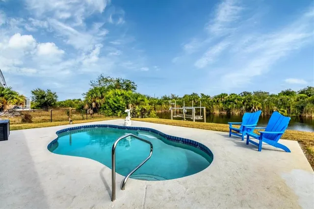 a view of swimming pool with seating area and barbeque oven