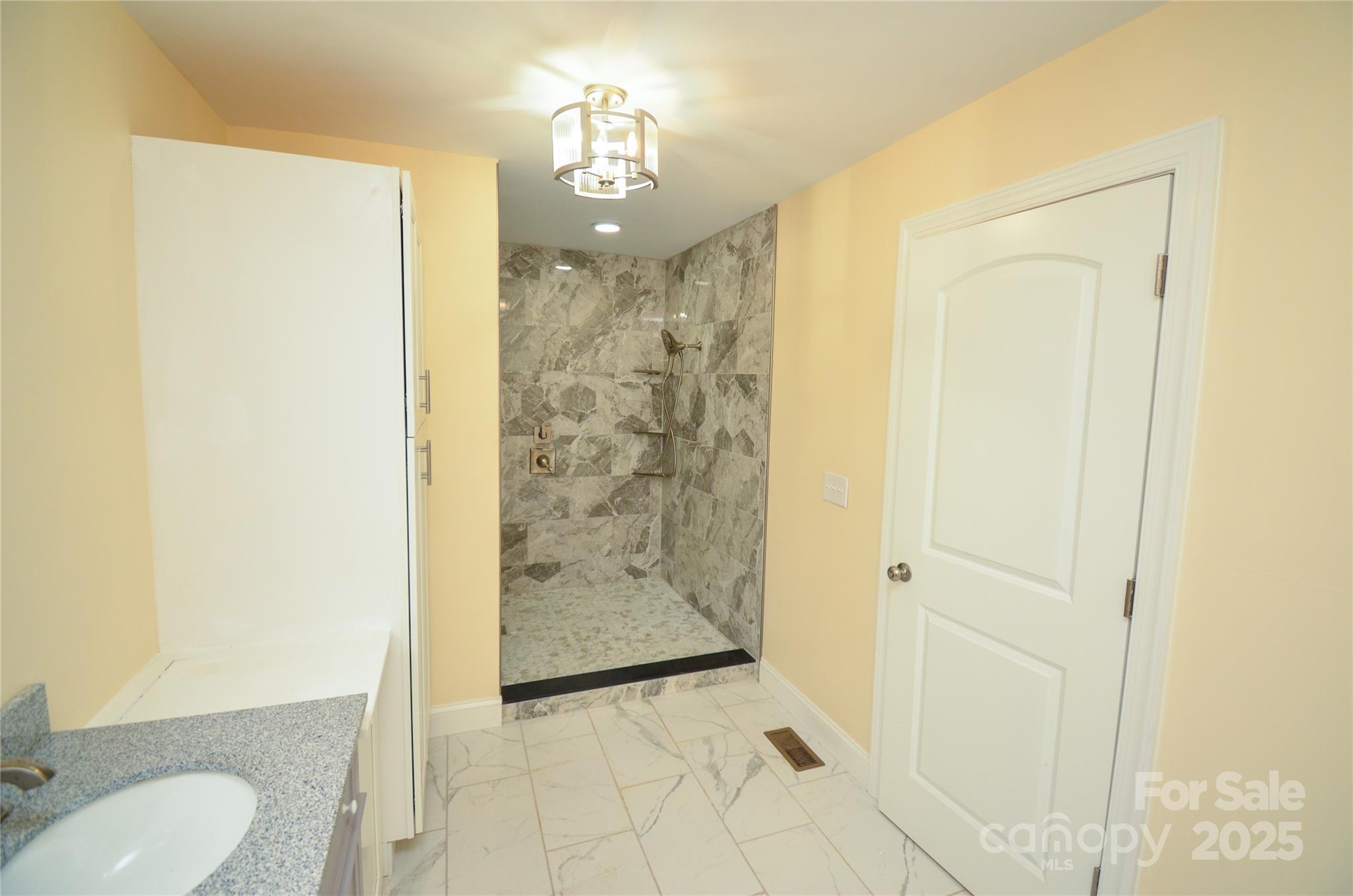 907 Carpenters Grove Church Road Lawndale, NC 28090 - Photo 17 of 33 a bathroom with a granite countertop shower a mirror and a toilet