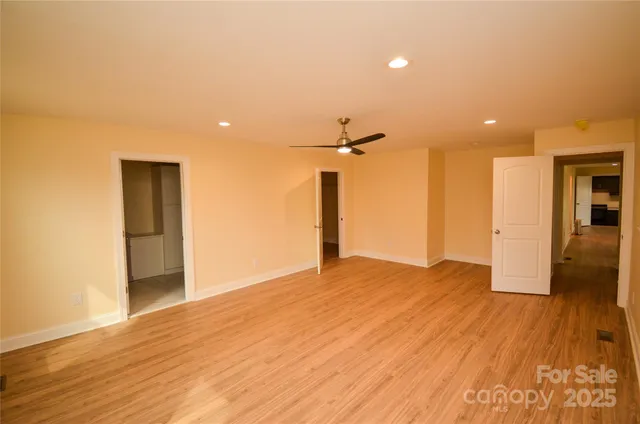 a view of empty room with wooden floor