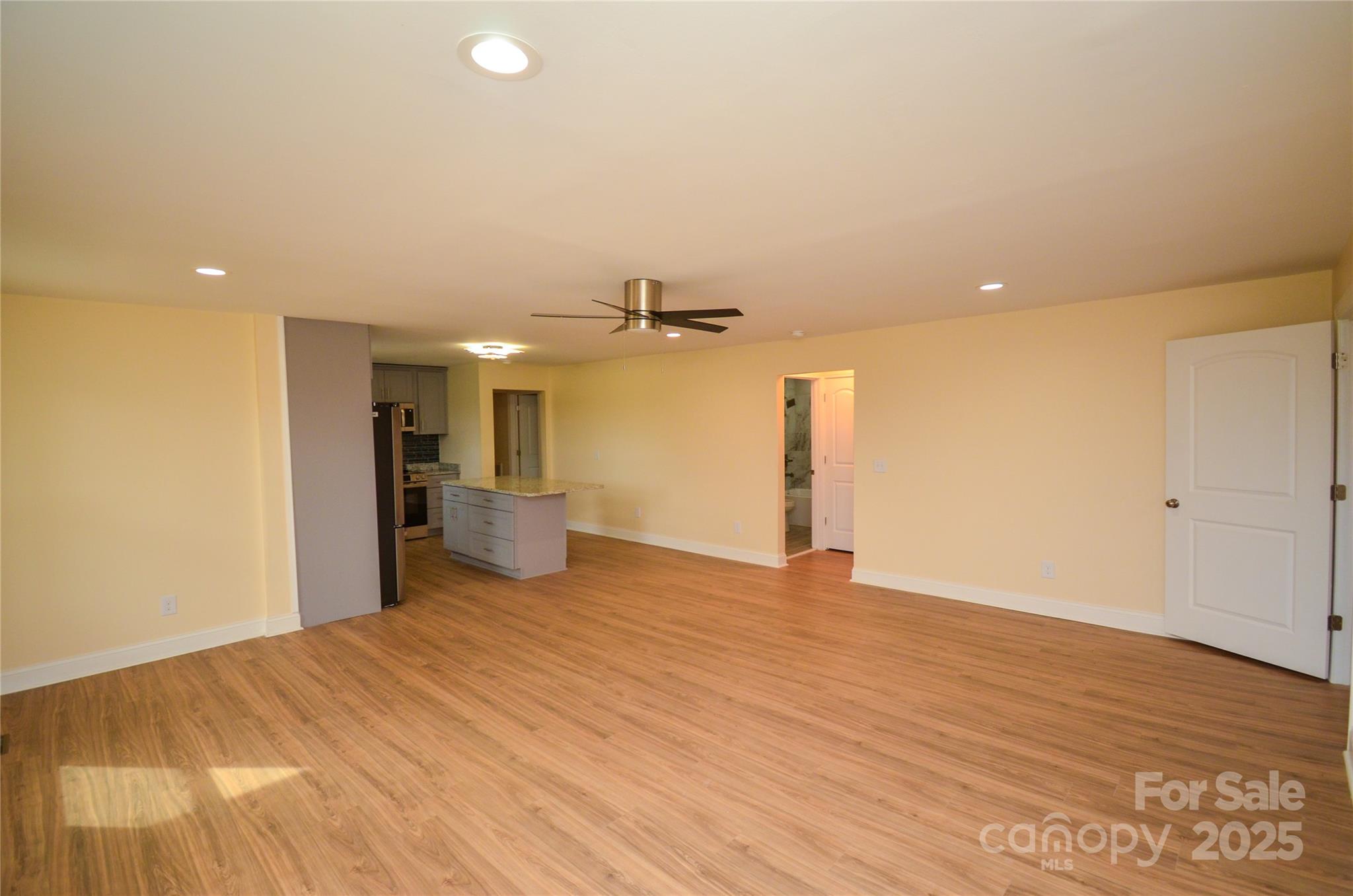 907 Carpenters Grove Church Road Lawndale, NC 28090 - Photo 33 of 33 a view of a big room with wooden floor a ceiling fan and kitchen view