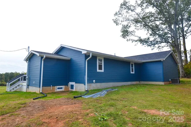 a backyard of a house with plants and a tree