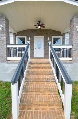 a view of staircase with lots of frames on wall and windows