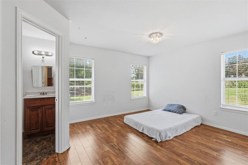 4417 Slayton Road Cleburne, TX 76031 - Photo 25 of 28 Spacious room featuring wood-finish flooring, white walls, and two windows with blinds