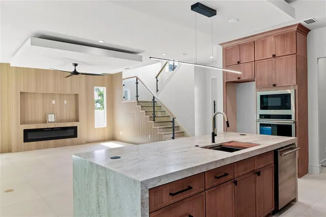 a kitchen with stainless steel appliances granite countertop a sink a stove and a refrigerator