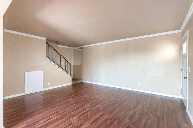 a view of an empty room with wooden floor