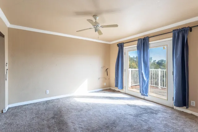 a view of a livingroom with a ceiling fan and window
