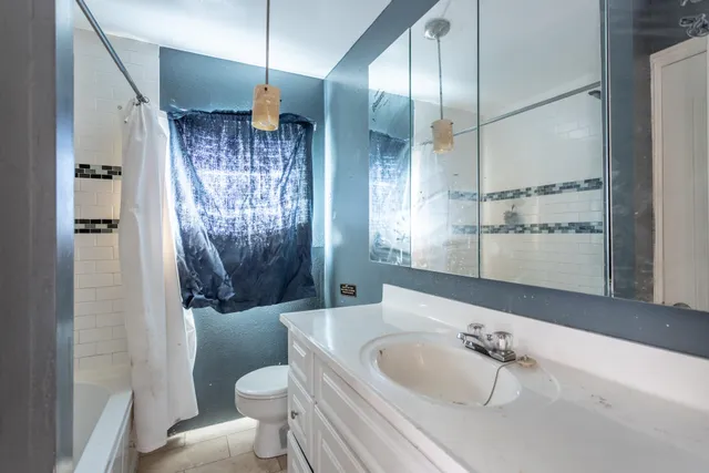 a bathroom with a granite countertop sink a toilet and shower